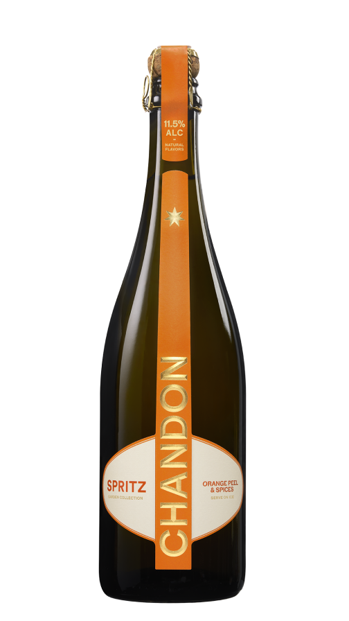 A single bottle of Chandon Spritz Orange Peels & Spices next to a glass of Chandon Spritz cocktail garnished with a dried orange slice and a sprig of rosemary, all on a gradient orange background.