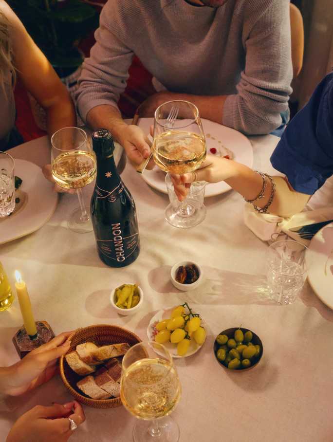 Amigos celebran con CHANDON Cuvée Brut Nature, vino espumoso de Mendoza, brindando en cena social.