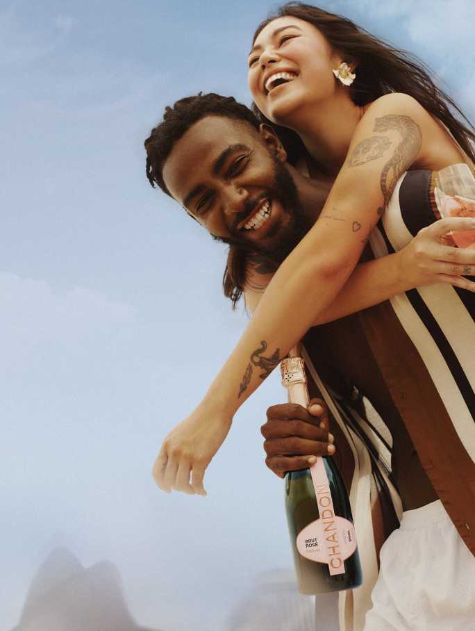 Um homem com uma garrafa de CHANDON rosé produzida no Brasil