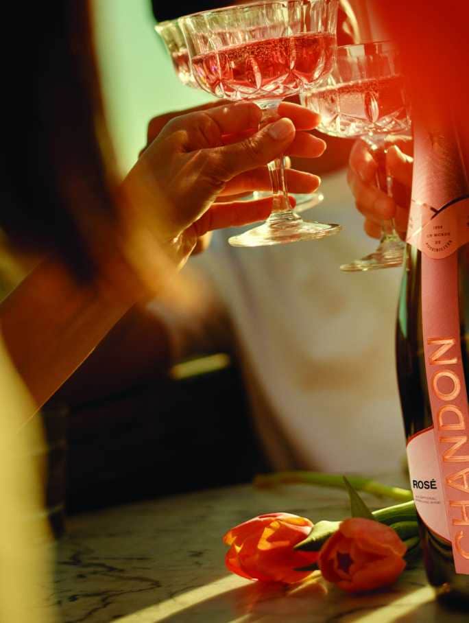 Celebración con CHANDON Rosé Mendoza, copas brindando, y tulipanes.