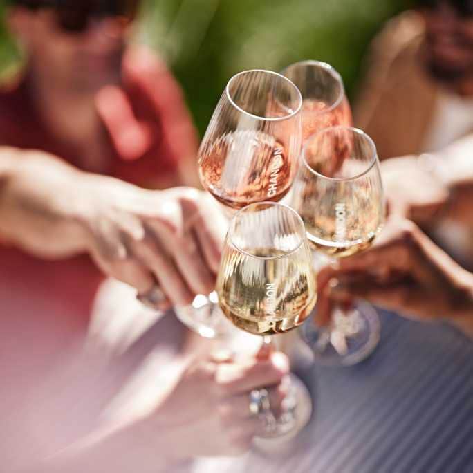 Brindis al sol con cuatro copas de espumante Chandon rosado y blanco entre amigos en Mendoza.