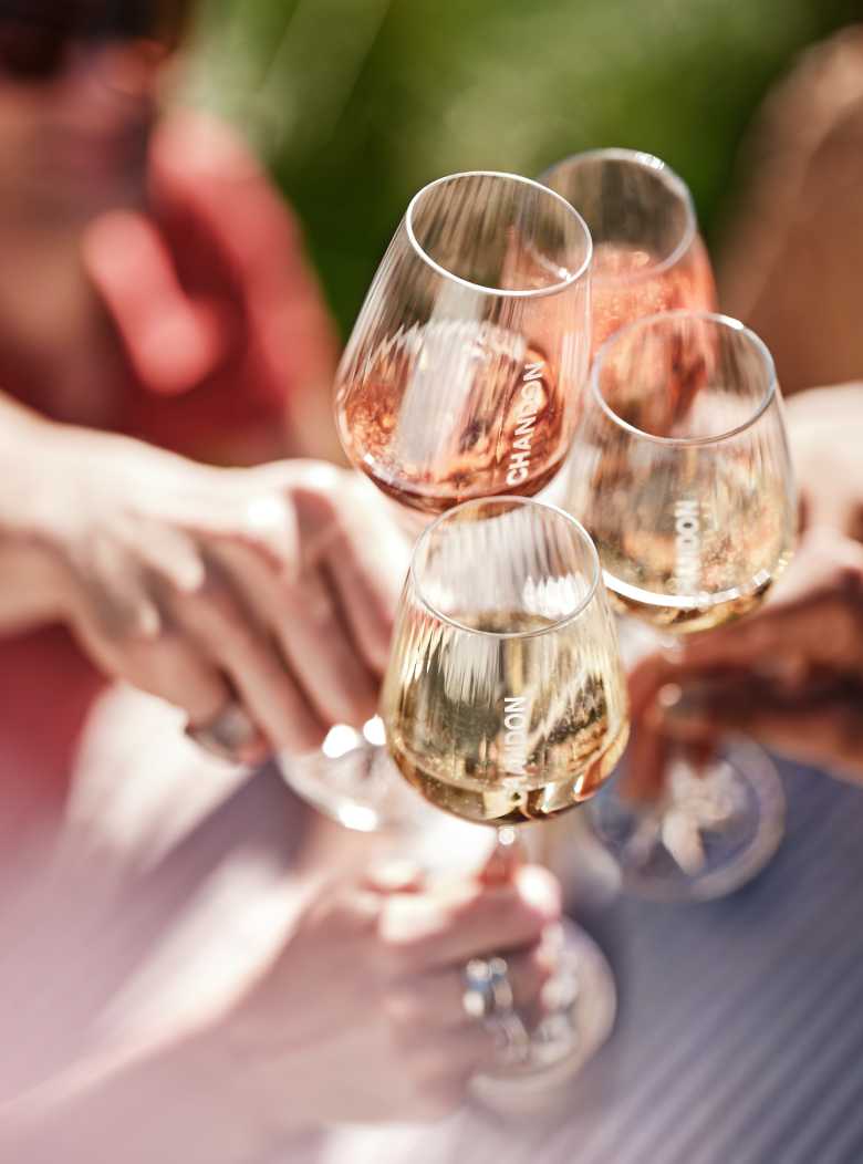 Brindis al sol con cuatro copas de espumante Chandon rosado y blanco entre amigos en Mendoza.
