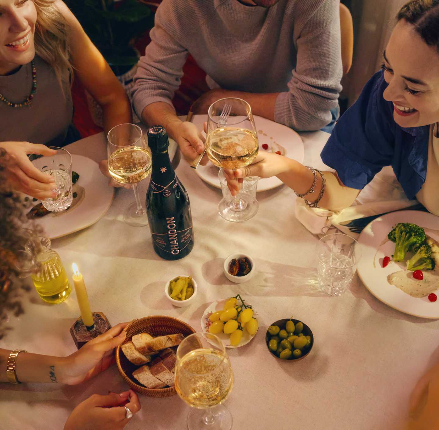 Amigos celebran con CHANDON Cuvée Brut Nature, vino espumoso de Mendoza, brindando en cena social.