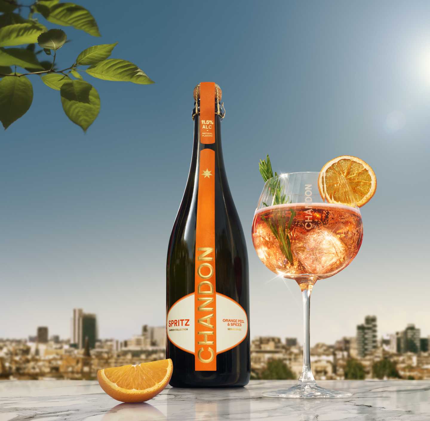 Chandon Spritz bottle and a glass of Chandon Spritz cocktail garnished with an orange slice and rosemary, set against a sunny cityscape background.