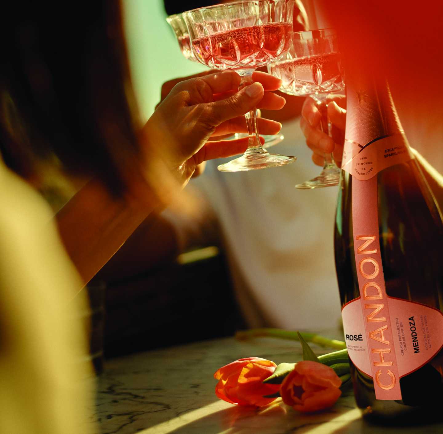 Celebración con CHANDON Rosé Mendoza, copas brindando, y tulipanes.