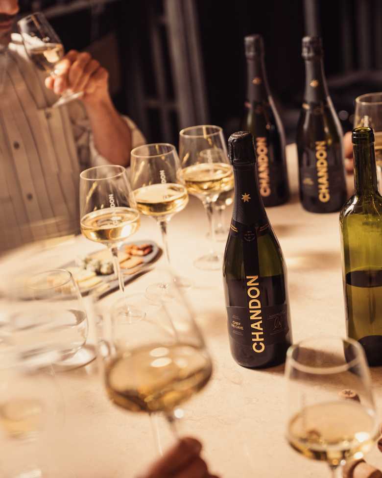 Degustación de CHANDON en Mendoza: gente probando espumantes con botellas de CHANDON Brut y Rosé en la mesa.