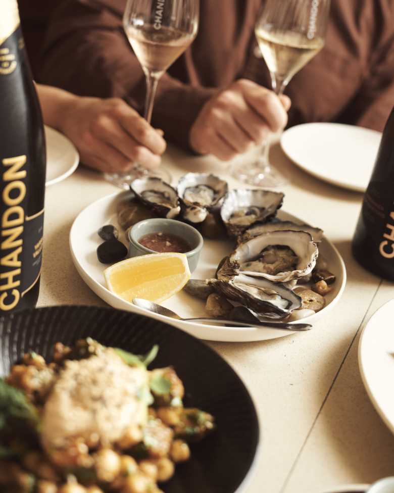 Dinning at the CHANDON BrandHome in Australia with CHANDON Bottle and Oyesters
