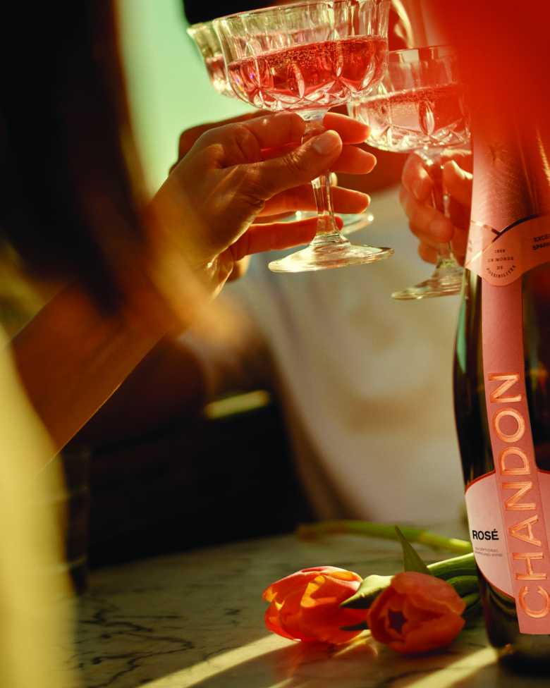 Celebración con CHANDON Rosé Mendoza, copas brindando, y tulipanes.